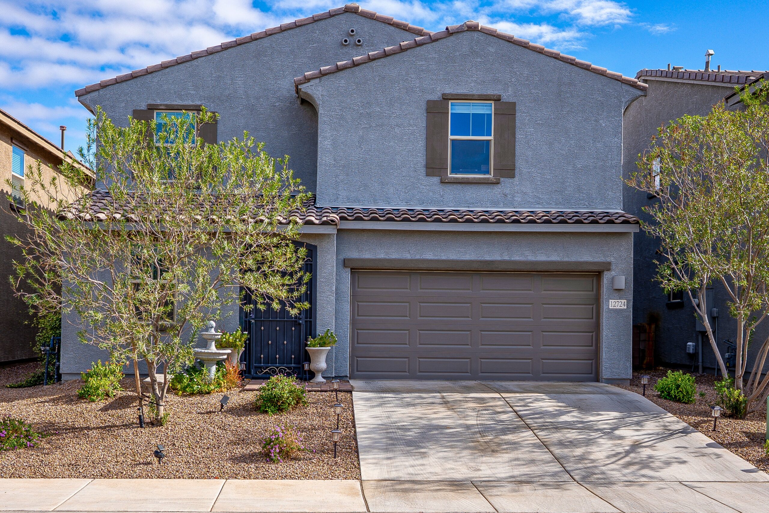 Two-story Marana home with a tile roof, two-car garage and desert landscaping
