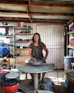 Maxine Krasnow stands at a potters wheel at the Tucson Clay Co-op