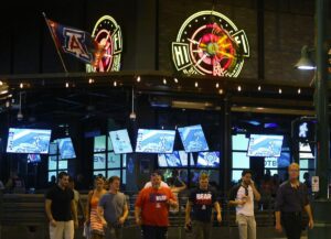 A group of Wildcat fans cross the street in front of Hi Fi